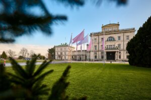 Villa Hügel mit wehenden rosa und weißen Fahnen im Vordergrund