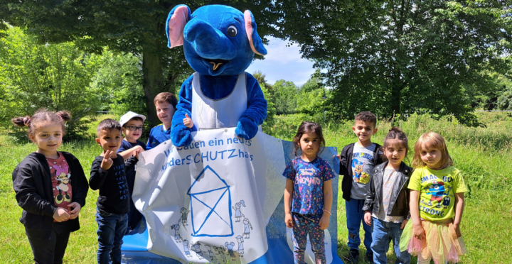 Kinderschutzhaus: Kinder mit Maskottchen