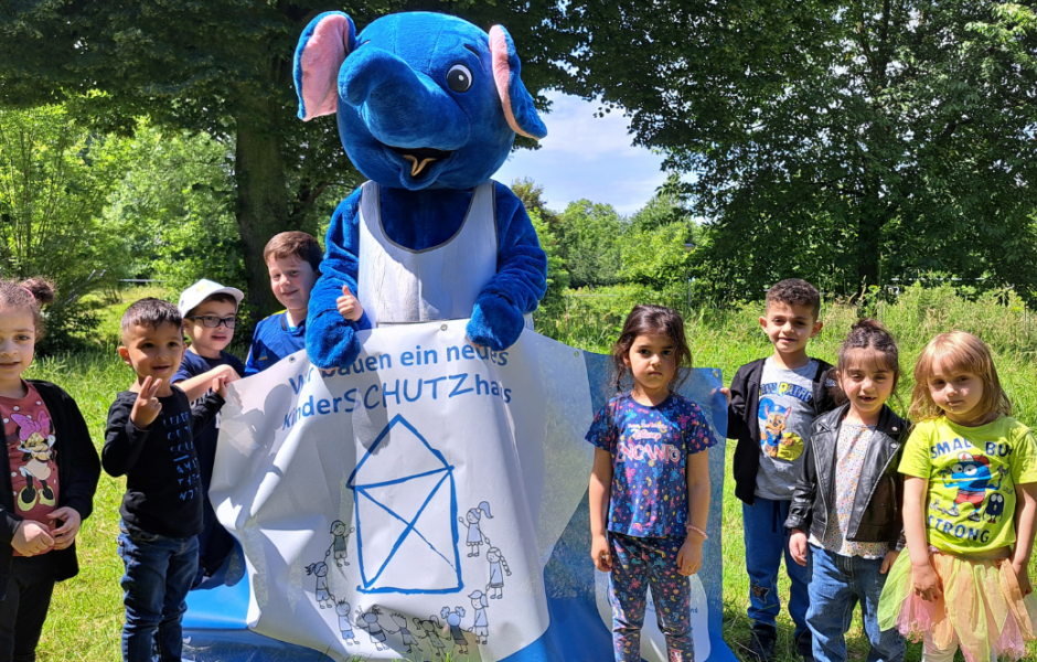 Kinderschutzhaus: Kinder mit Maskottchen