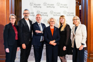 Dr. Michaela Muylkens, Volker Troche, Prof. Peter Gorschlüter, Regina Selter, Sarah Bockting, Prof. Dr. Dr. h.c. Ursula Gather stehen vor der Pressewand in der Villa Hügel