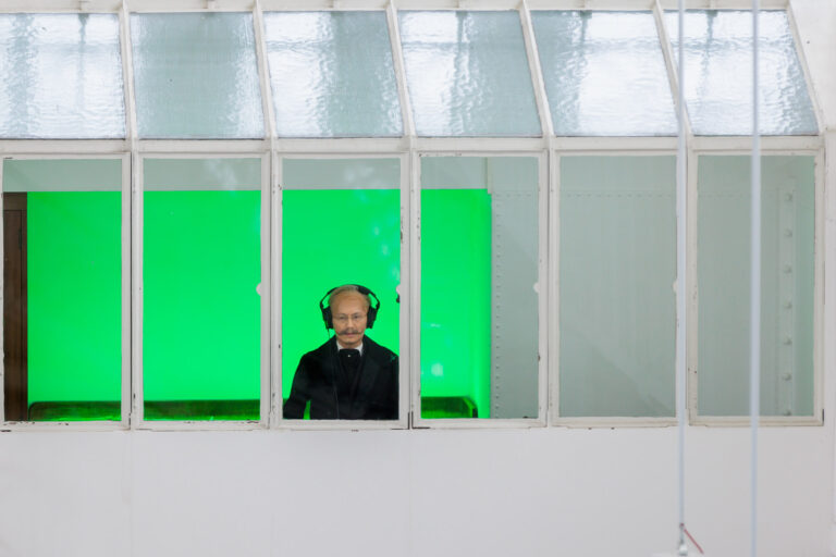 Samson Young verkleidet in der Villa Hügel mit grünem Licht im Hintergrund.