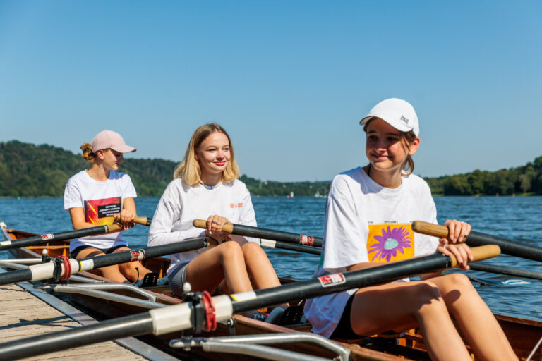 Drei Mädchen rudern auf dem See