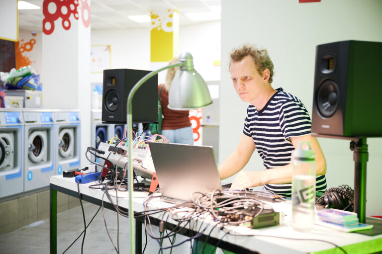 Rasmus Nordholt-Frieling sitzt am Computer im Waschsalon in Essen