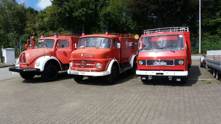 Drei Spielmobile, historische Feuerwehrwagen, stehen nebenenainder