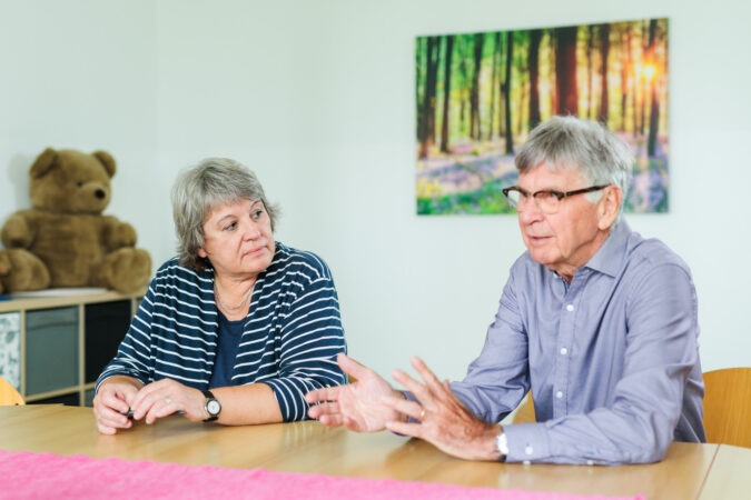 Ute Kalvelis, links und Dr. Ulrich Kohns, rechts, sitzen nebeneinander an einem Tisch und stellen das Projekt vor.