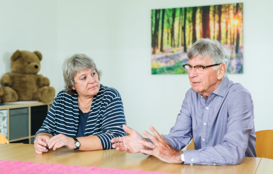 Ute Kalvelis, links und Dr. Ulrich Kohns, rechts, sitzen nebeneinander an einem Tisch und stellen das Projekt vor.