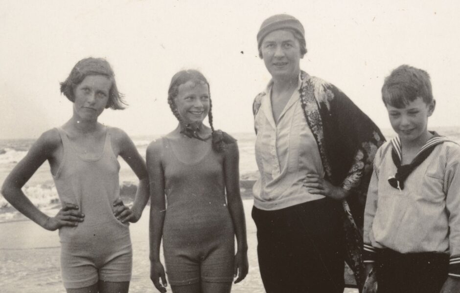 Drei Kinder mit ihrer Hauslehrerin am Strand