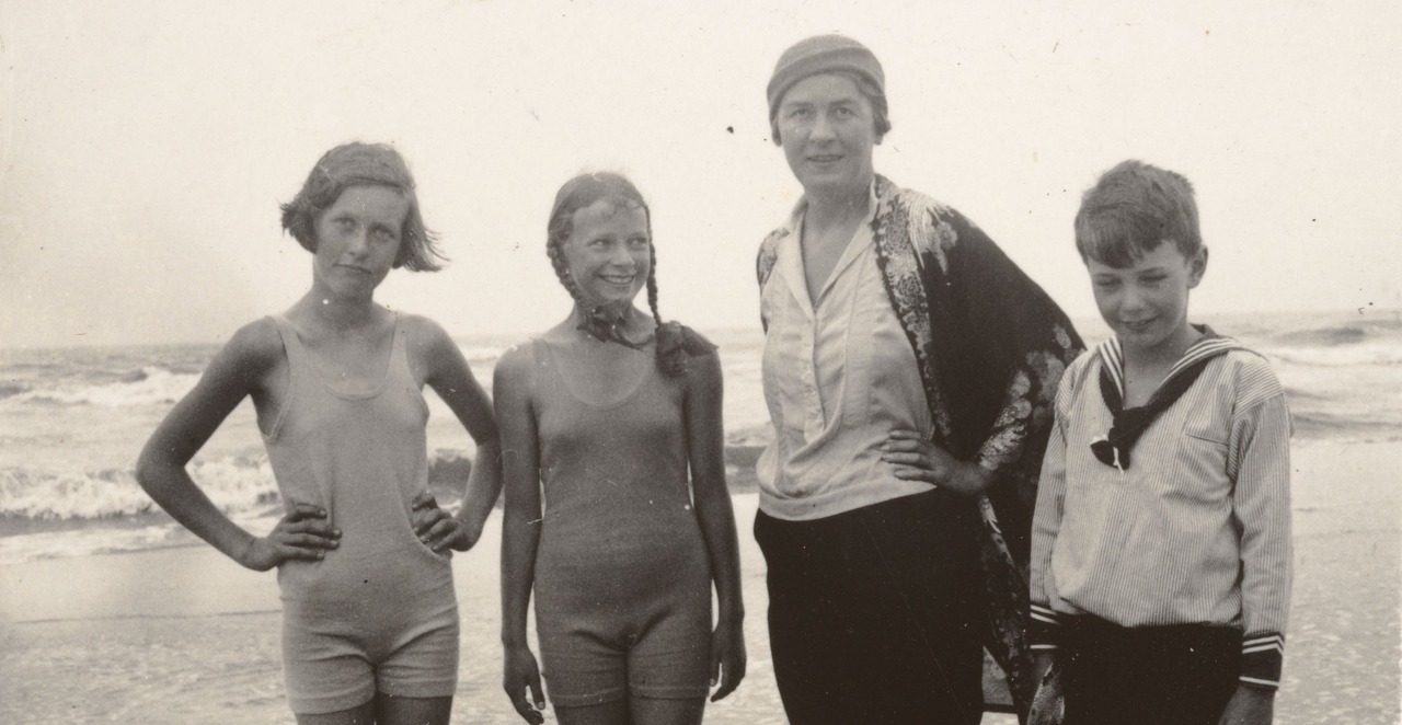 Drei Kinder mit ihrer Hauslehrerin am Strand