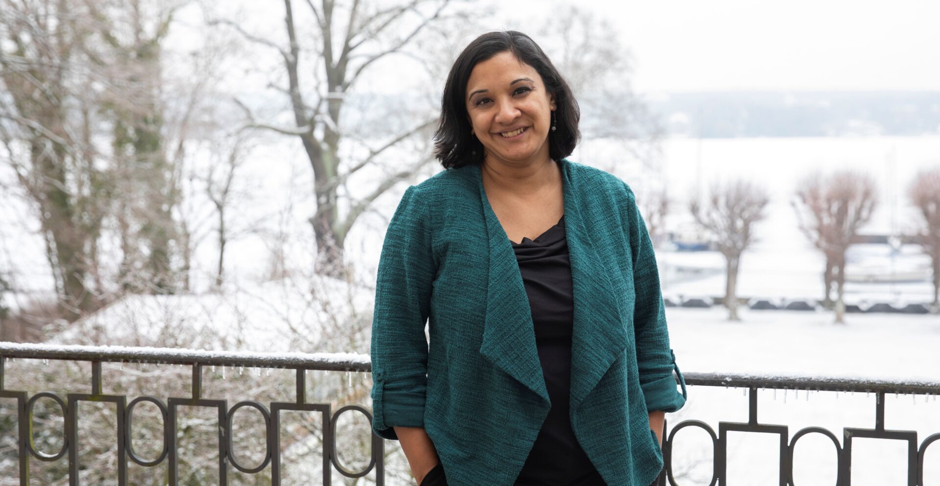 Eine Frau, die in lächelnd in die Kamera blickt.