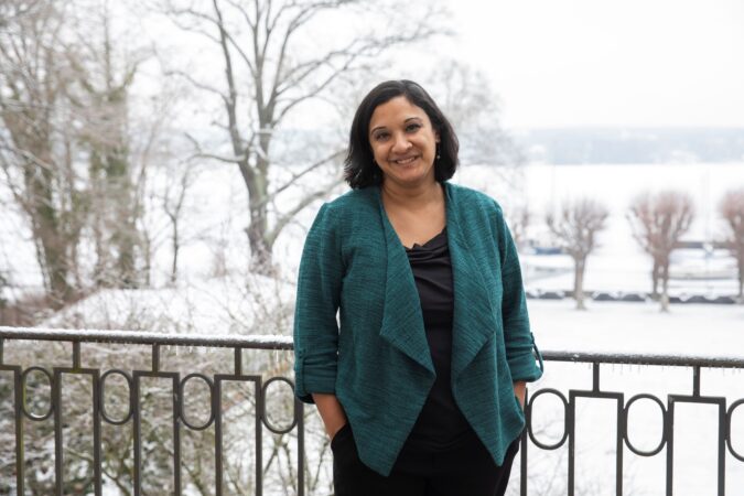 Eine Frau, die in lächelnd in die Kamera blickt.