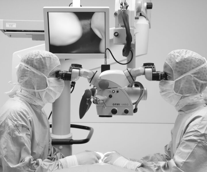Doctors working with a microscope in an operating room.