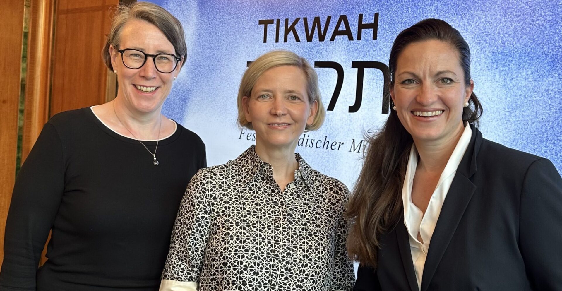 Three Women in front of a Screen.