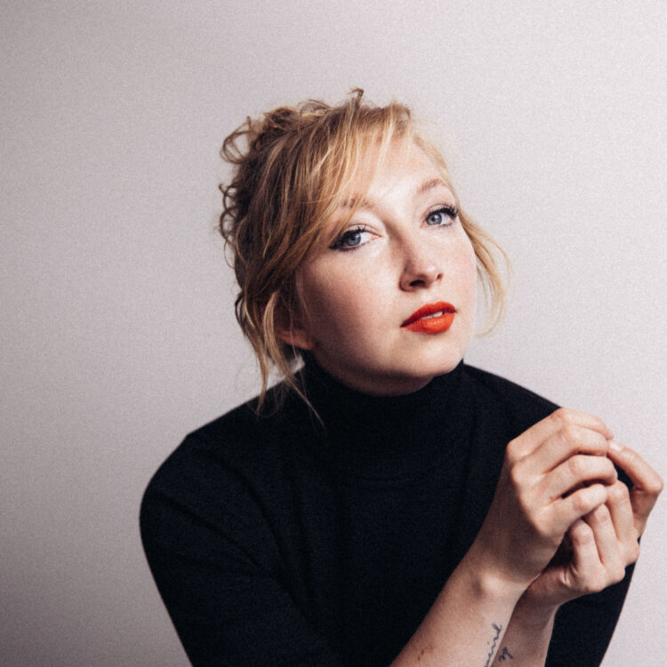 Porträt der Musikerin Nina Graf. im Querformat. Die trägt einen schwarzen Rollkragenpulli.