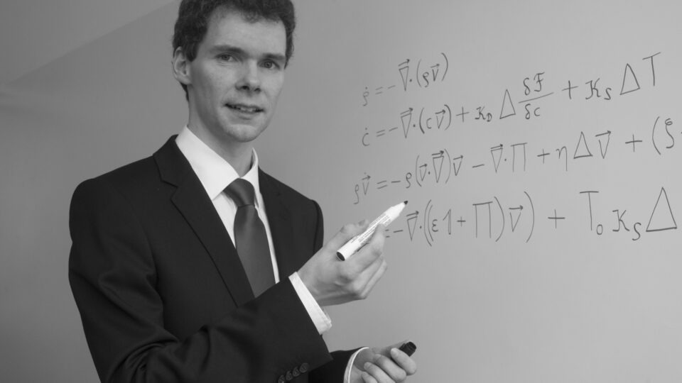 Der Preisträger Prof. Dr. Raffael Wittkowski steht an einem Whiteboard